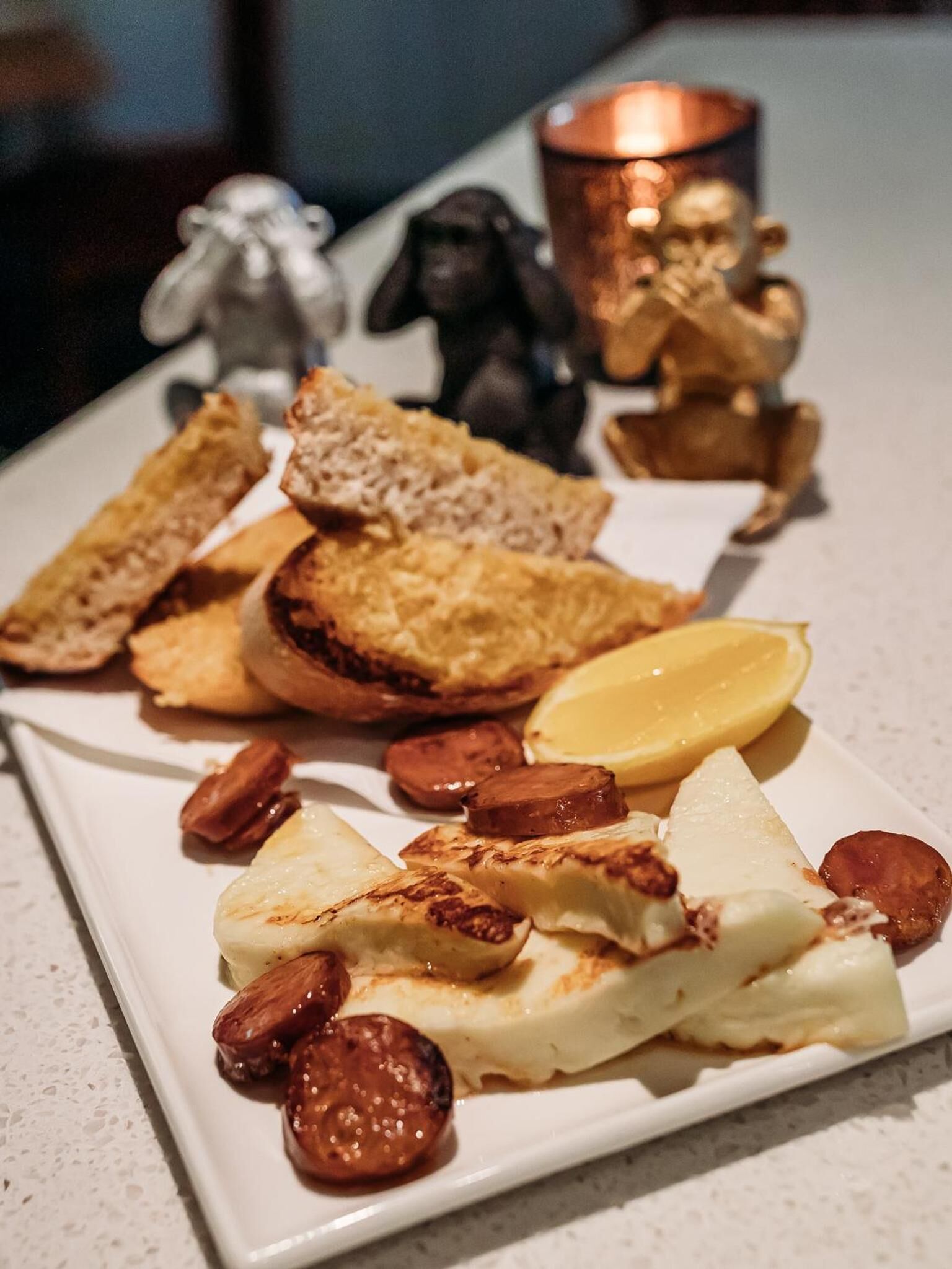 Un plato de comida con pan, queso y lonchas de salchicha.