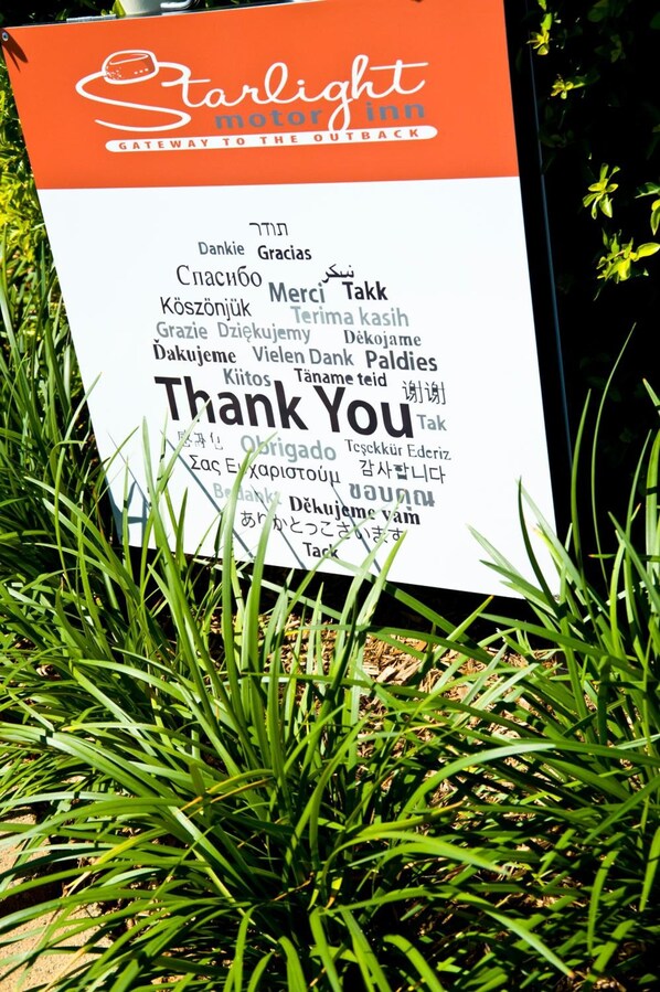 A signboard with multilingual 'Thank You' messages and the logo of 'Starlight Motor Inn'.