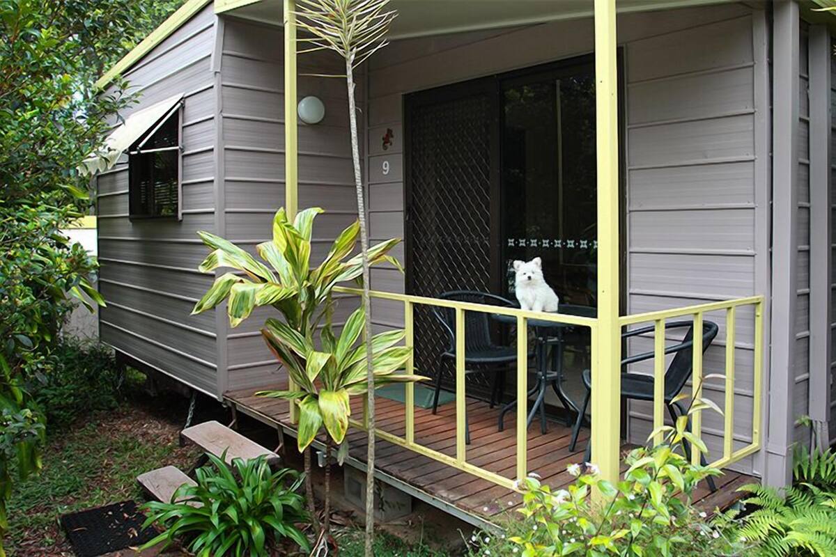 A house with a porch, a small table, and a chair.