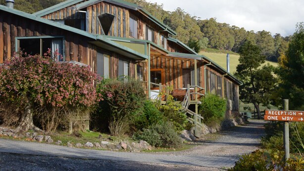A rustic wooden building with a reception sign indicating a one-way entrance. - Silver Ridge Retreat (Claude Road)