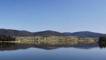 A calm lake with mountains in the background.