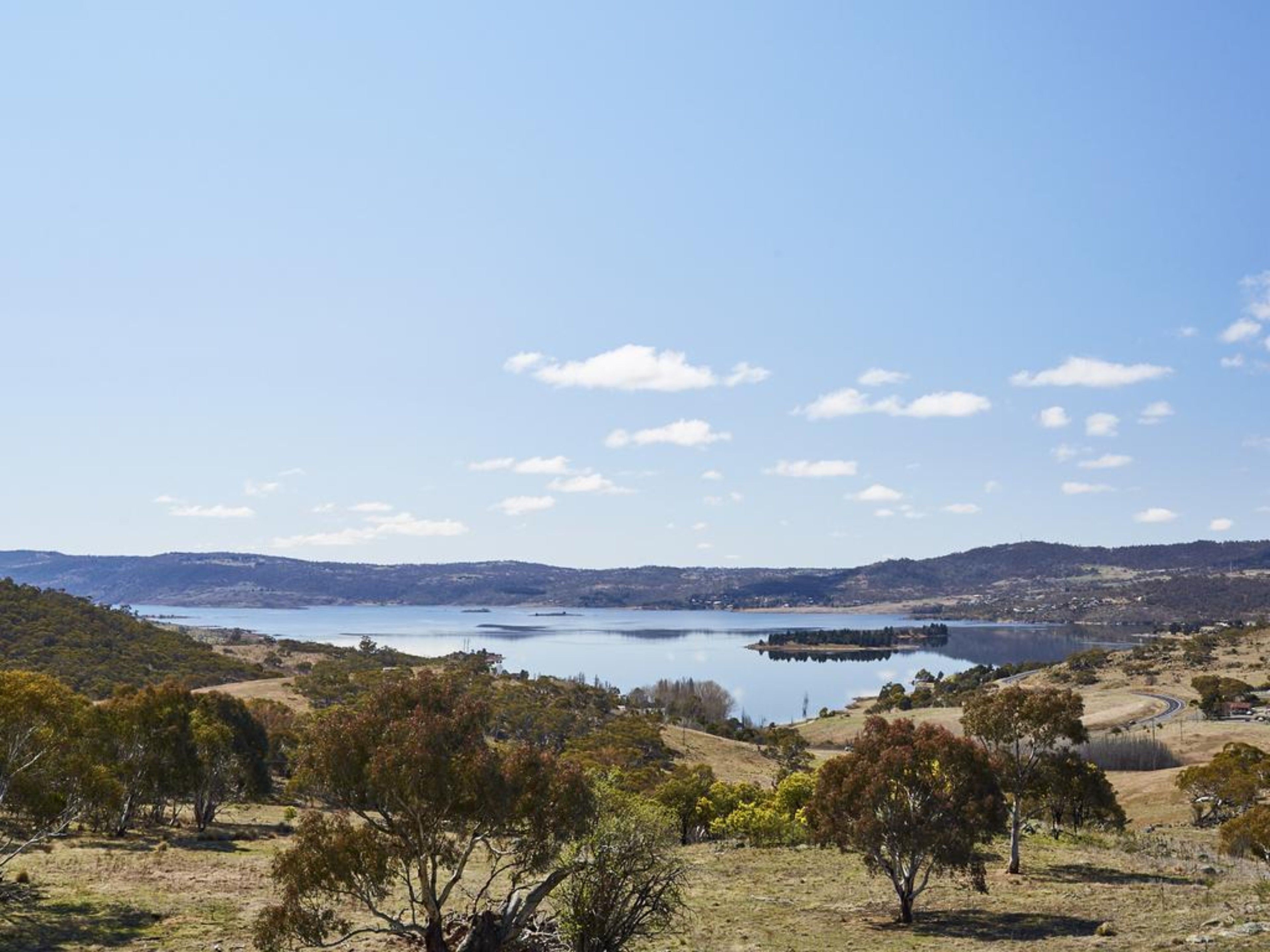 Un lago rodeado de colinas y vegetación escasa.