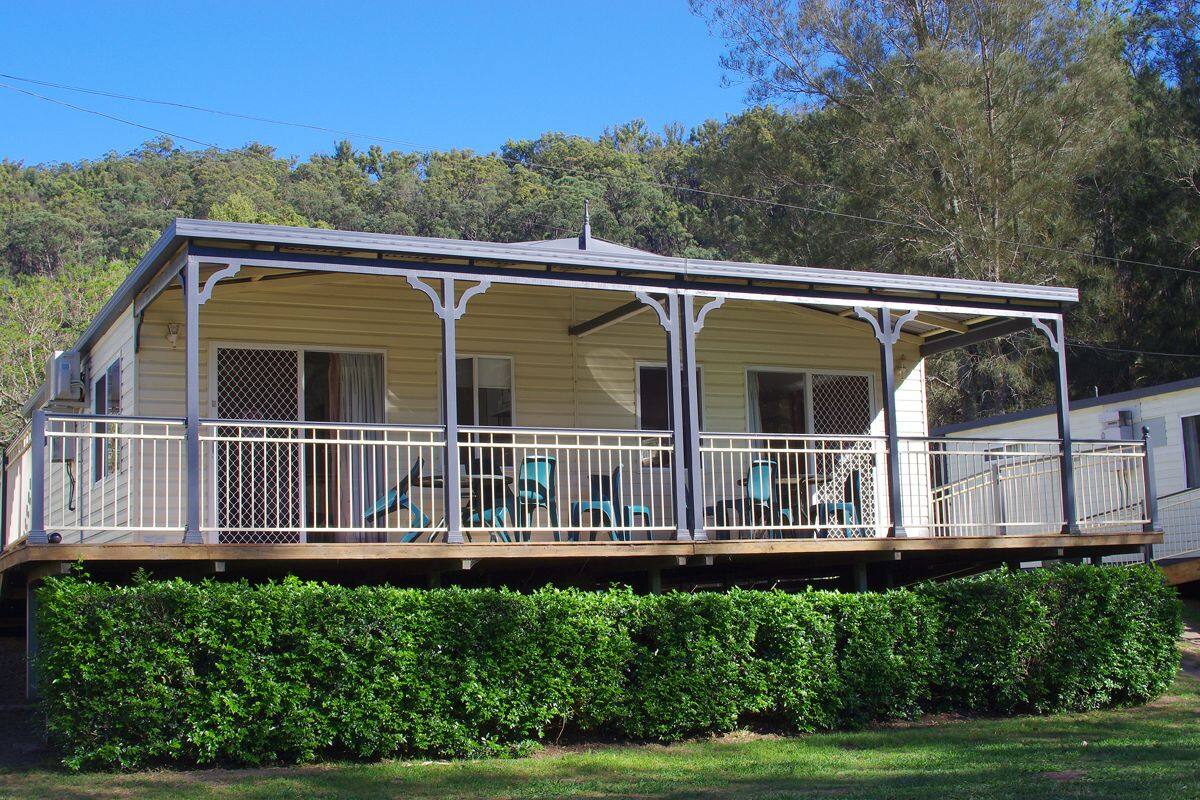 A two-story house with a covered porch and a fenced deck area.