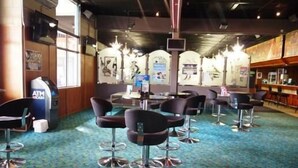 A bar area with multiple stools and a counter. - Jolly Collier Hotel Motel (Dysart)