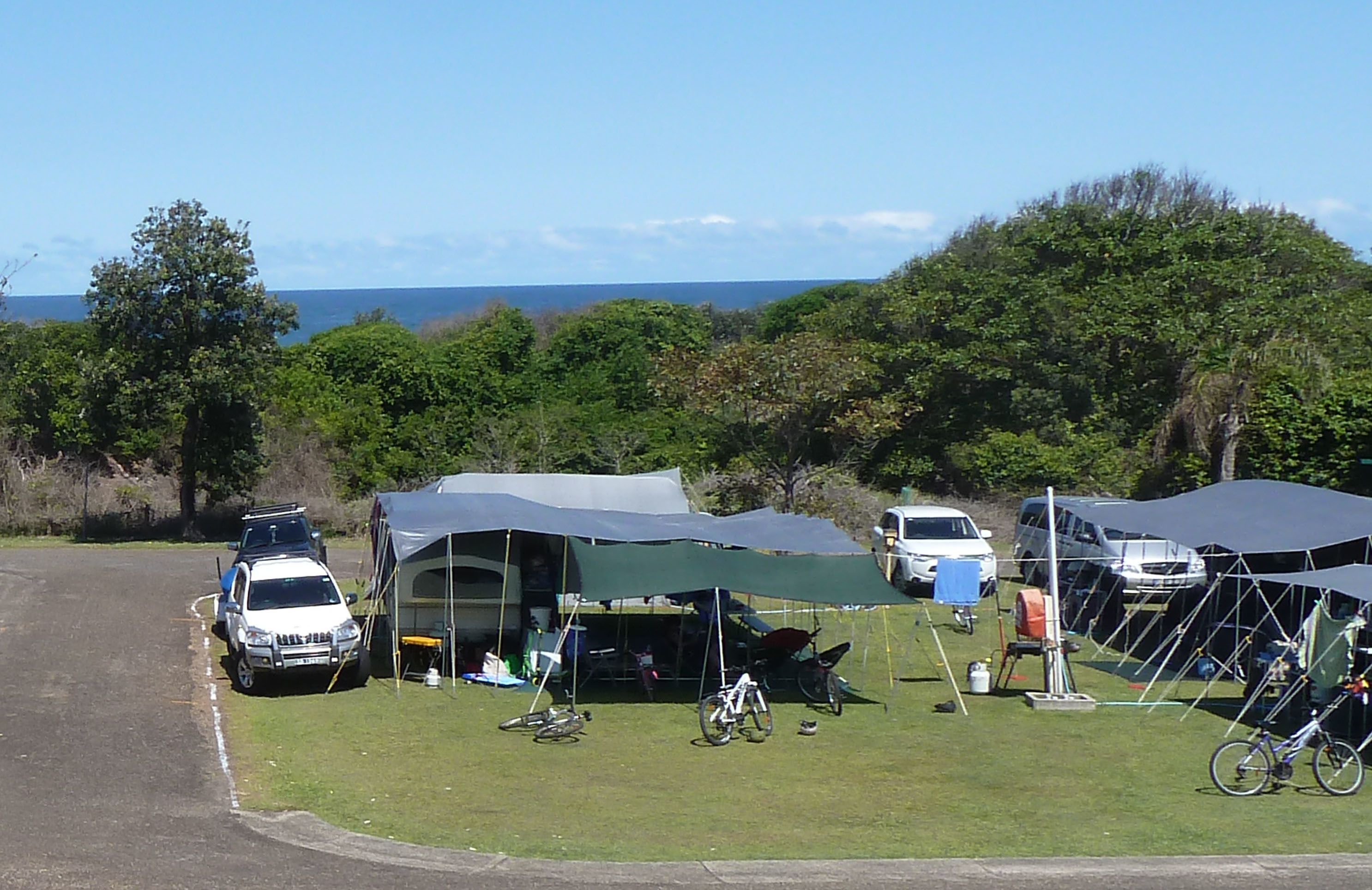 A campsite with tents, a white SUV, and bicycles.