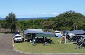 A campsite with tents, a white SUV, and bicycles. - Lanis on the Beach - Old Bar (Old Bar)