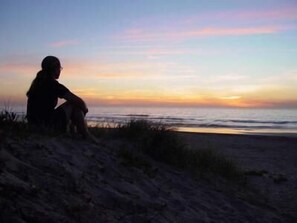 A person sitting on a sandy beach at sunset. - Lanis on the Beach - Old Bar (Old Bar)