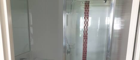 A bathroom with a toilet, sink, and shower.