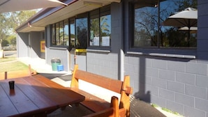 Un restaurant avec une terrasse, une vue dégagée sur la rue et une enseigne indiquant qu’il s’agit d’un point de service Hertz.