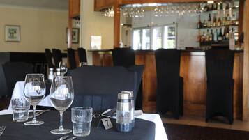 Une table à manger dressée avec des verres à vin, un salière et un poivrière, et un numéro de table.