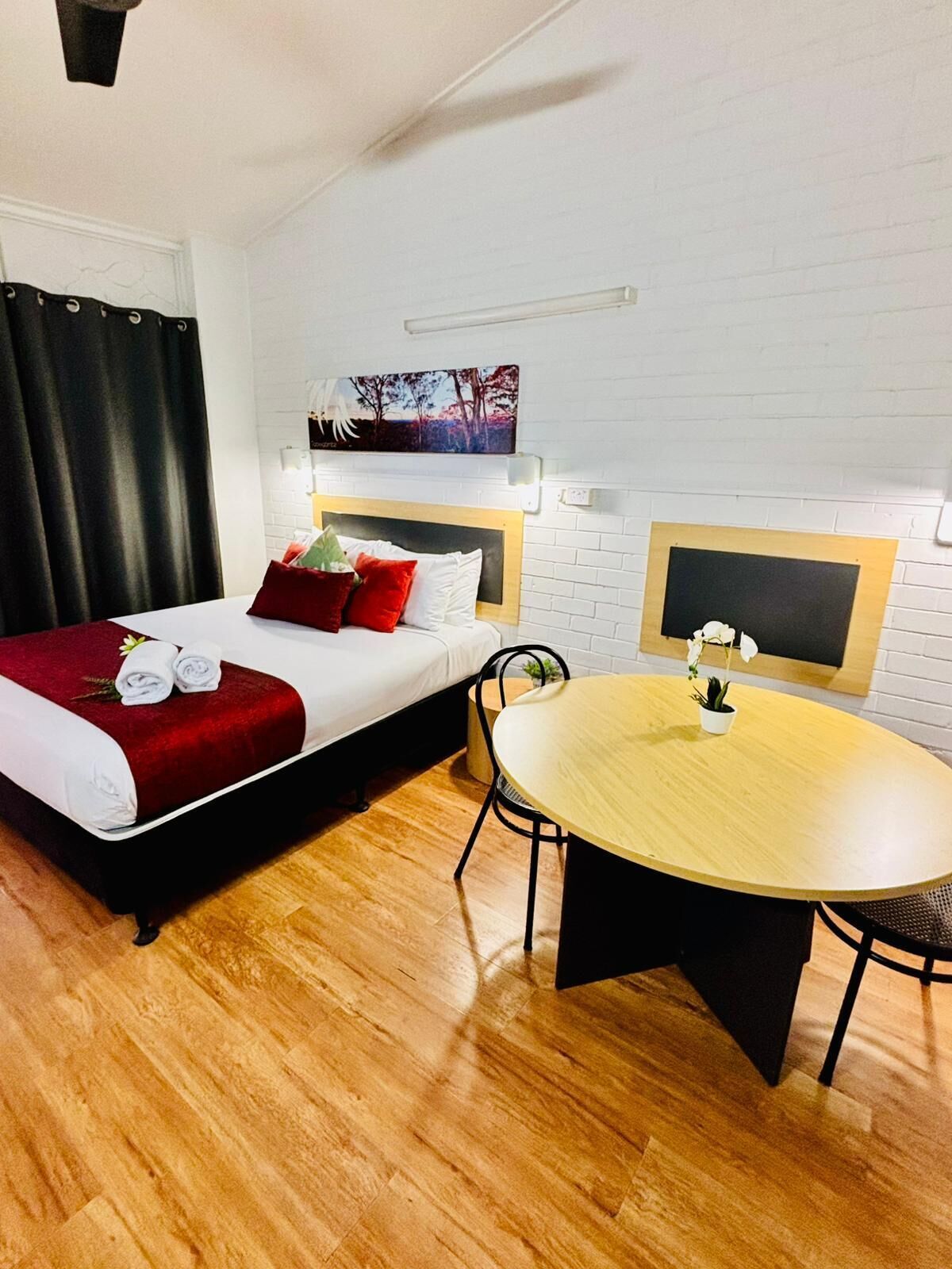 Ein Hotelzimmer mit einem Bett, einem kleinen Tisch und einem Sessel.
