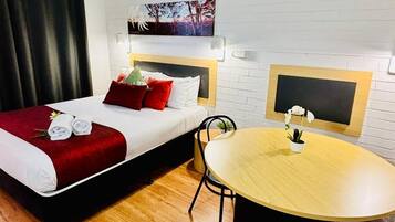 Ein Hotelzimmer mit einem Bett, einem kleinen Tisch und einem Sessel.