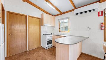 A modern kitchen with wooden cabinets, a built-in stove, and a large island.