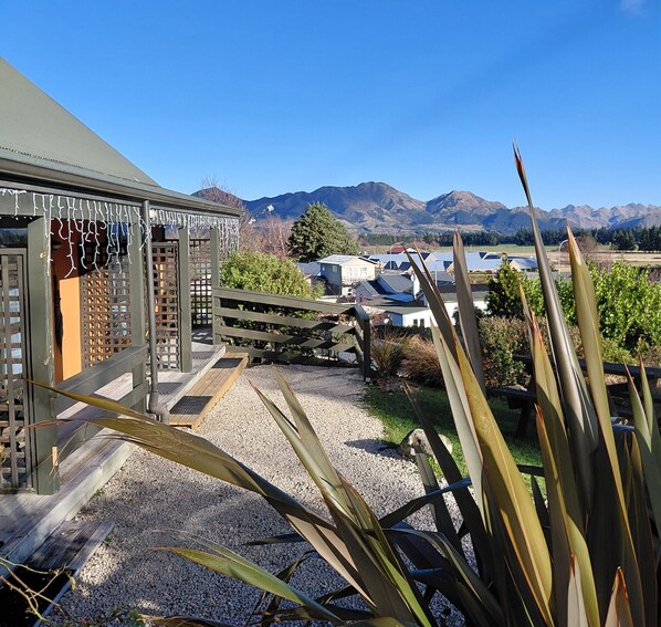 A building with a wooden deck and a view of mountains. - Alpine Garden Motel (Hanmer Springs)