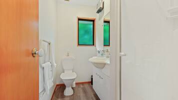 A small bathroom with a toilet, sink, and mirror.