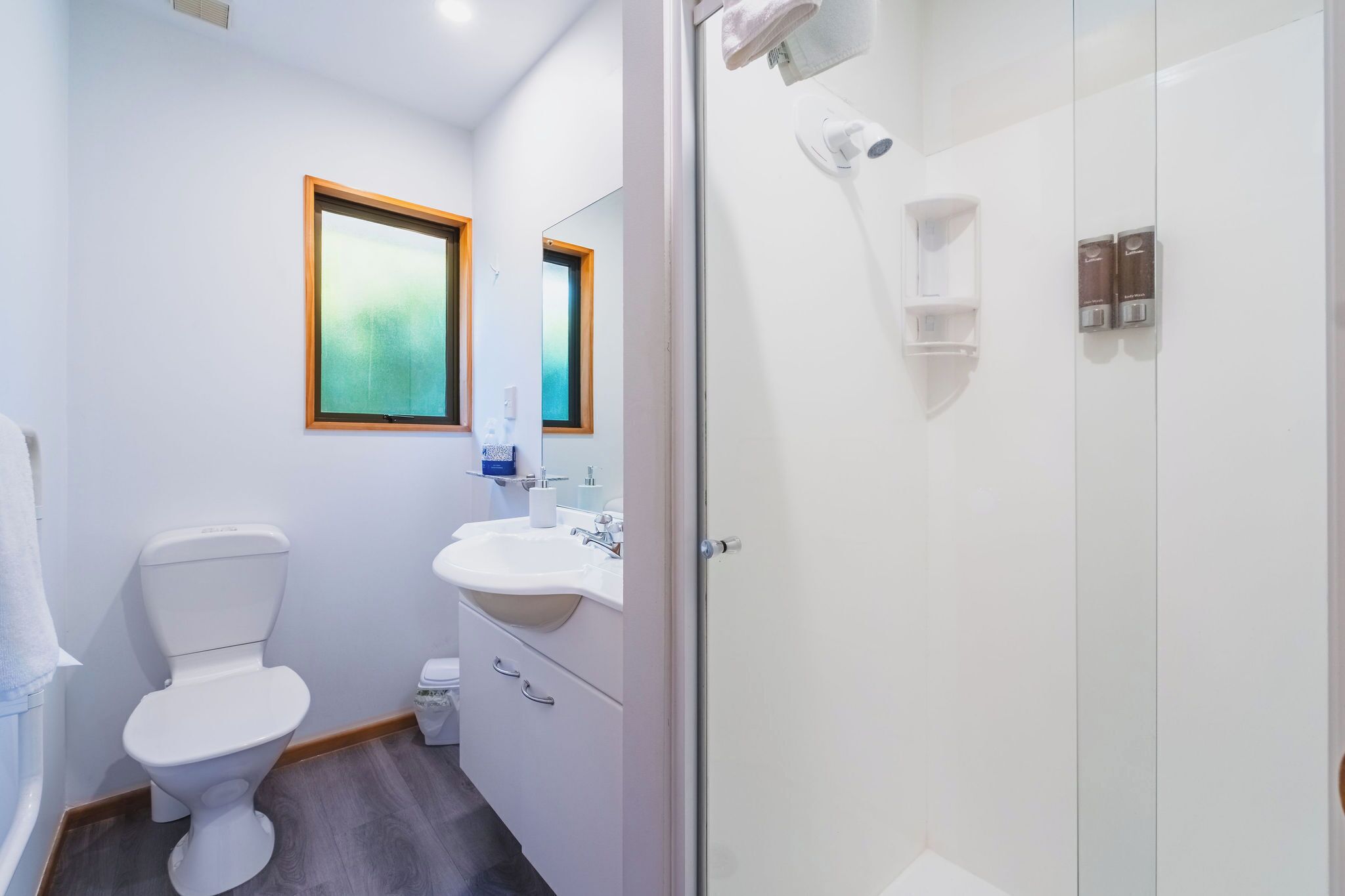 Ein modernes Badezimmer mit Toilette, Waschbecken und Dusche.
