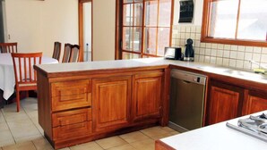 Una cocina con armarios de madera, lavavajillas y ventana con vistas.