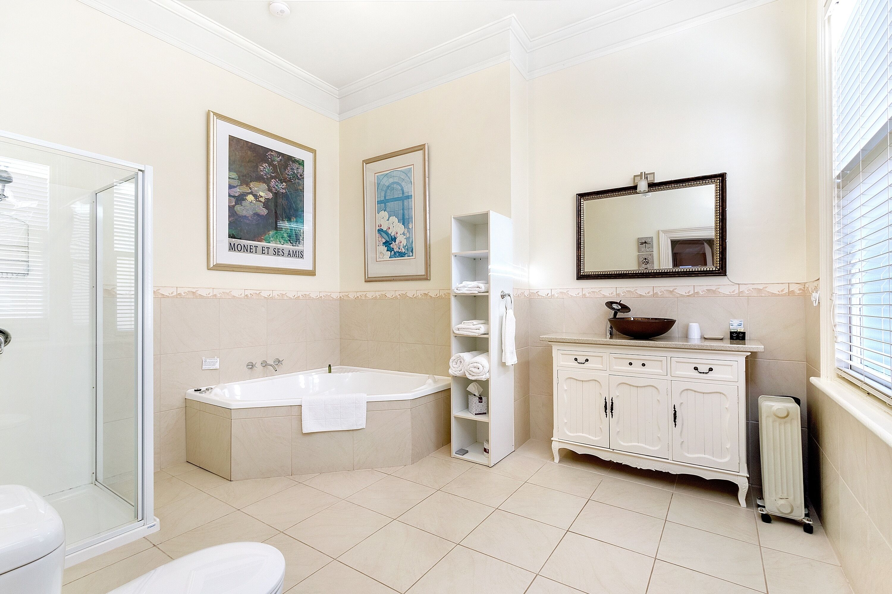 Un baño con bañera, ducha, inodoro, lavamanos, espejo y armario.