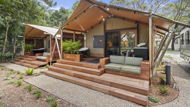 Un espacio exterior moderno con porche cubierto, asientos integrados y zona de barbacoa.