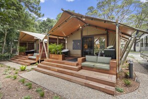 Un espacio exterior moderno con porche cubierto, asientos integrados y zona de barbacoa.