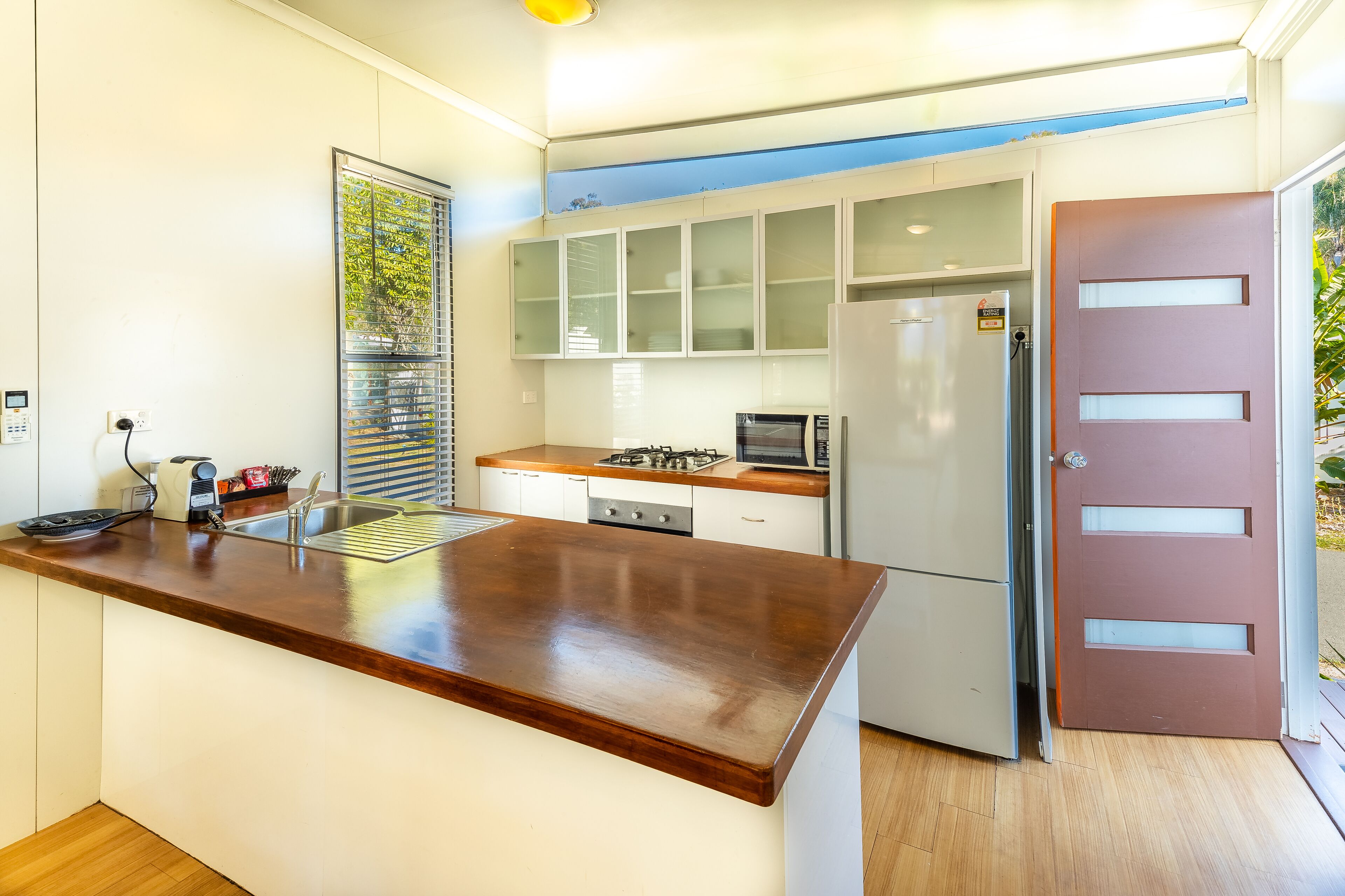 A modern kitchen with a wooden countertop, stainless steel appliances, and a built-in oven.