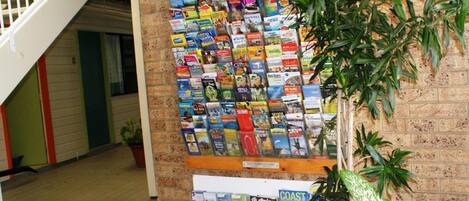 A bulletin board with travel brochures and a sign indicating visitor information.