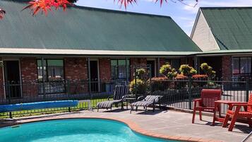 Una piscina al aire libre de temporada, sombrillas