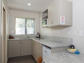 Executive studio | Privékitchenette | Een mini-koelkast, een magnetron, een kookplaat, een waterkoker