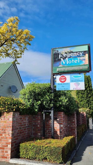 A motel sign with amenities including a seasonal heated pool, smart TV, and a book direct booking option. - Ashburton's Regency Motel (Ashburton)