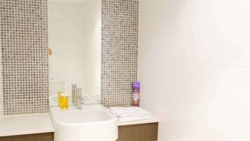 A bathroom with a white sink, two wall-mounted lights, and a mirror.
