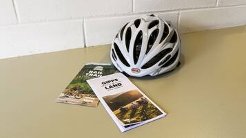 A white bicycle helmet and two travel brochures on a beige surface.