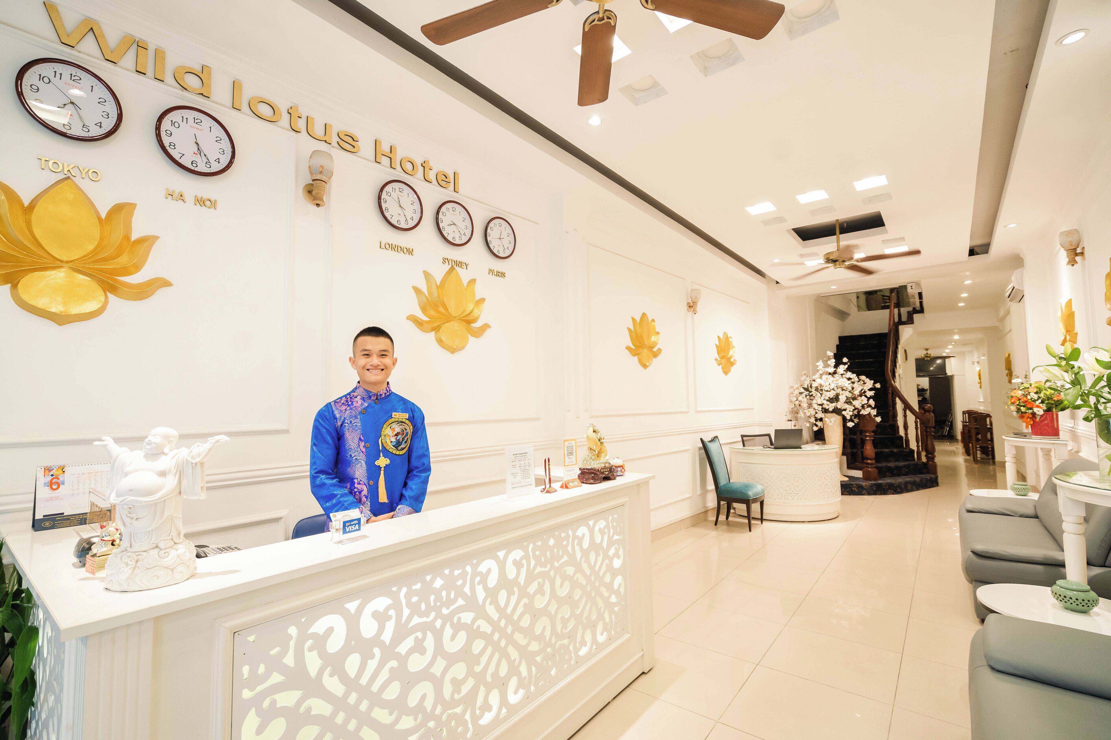 A reception desk at the Wild Lotus Hotel with clocks displaying times from Tokyo, London, Sydney, and Paris.
