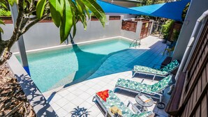 A rooftop pool area with lounge chairs and a small table. - Loka Santi (Agnes Water)