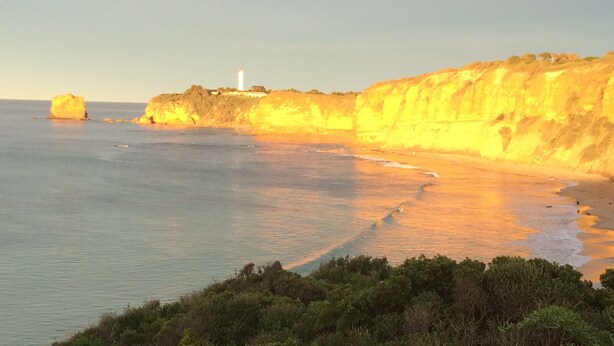 A coastal landscape with cliffs, a lighthouse, and a beach. - Split Point Cottages (Aireys Inlet)