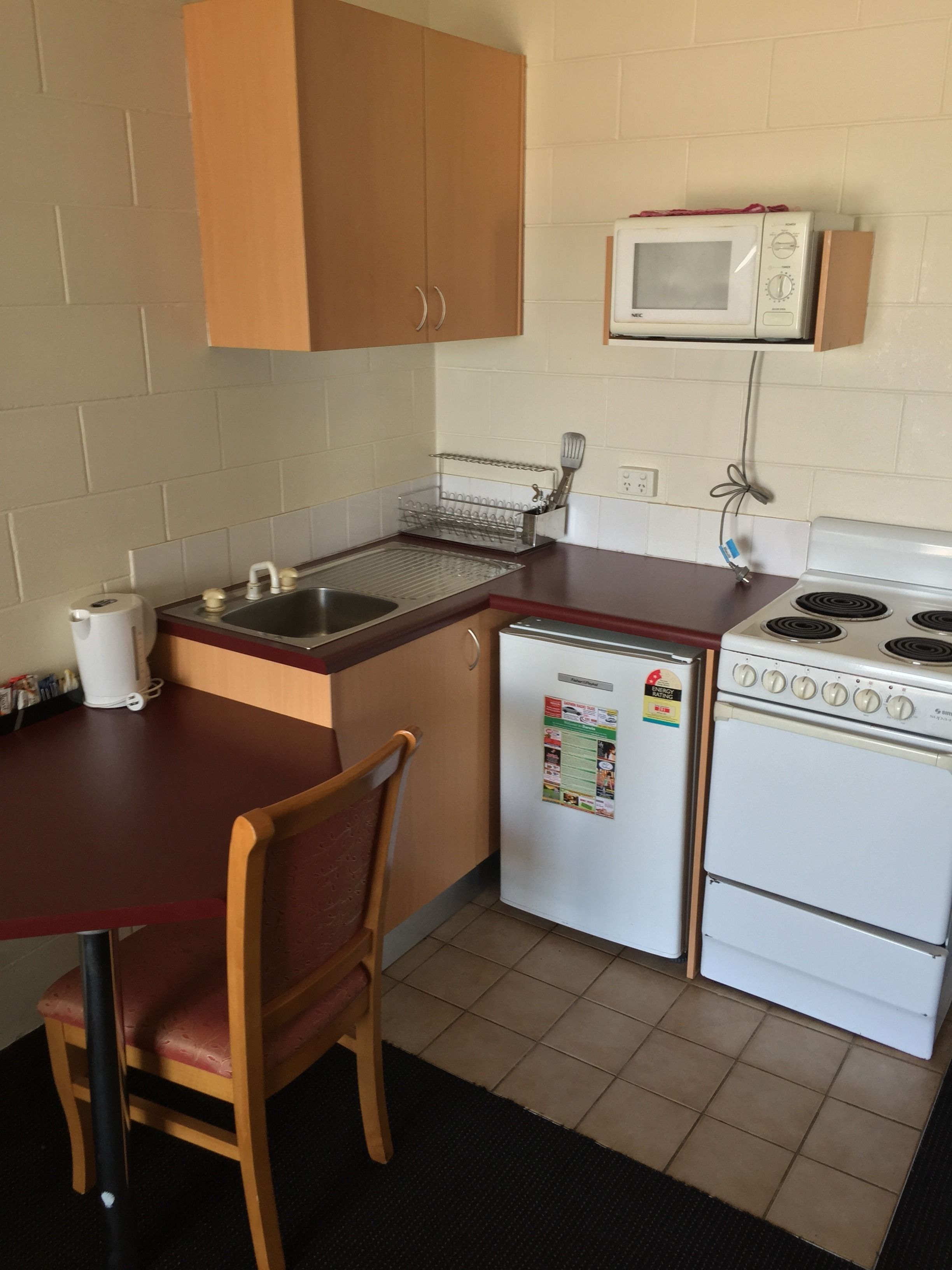 A compact kitchen with a sink, a microwave, a refrigerator, and a stove.