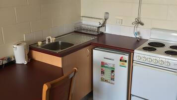A compact kitchen with a sink, a microwave, a refrigerator, and a stove.