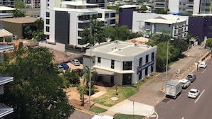 Un quartier urbain moderne, caractérisé par de grands immeubles, un mélange de bâtiments commerciaux et résidentiels, et un ciel dégagé.
