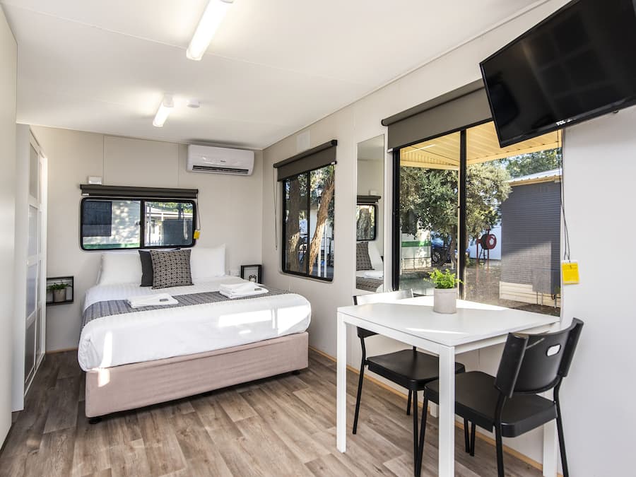 Cortinas blackout, tabla de planchar con plancha y ropa de cama