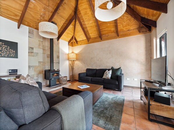 A modern living room with a fireplace, a sofa, a coffee table, and a TV. - Forest Rise (Yelverton)