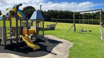 Children can play on the playground's slide, swing set, and shelter.