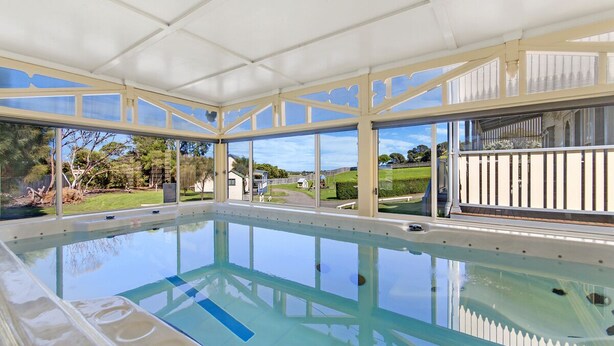 An indoor swimming pool with a clear view of the surrounding landscape. - Dunes - elegant beach villa with huge swim spa (Port Fairy)