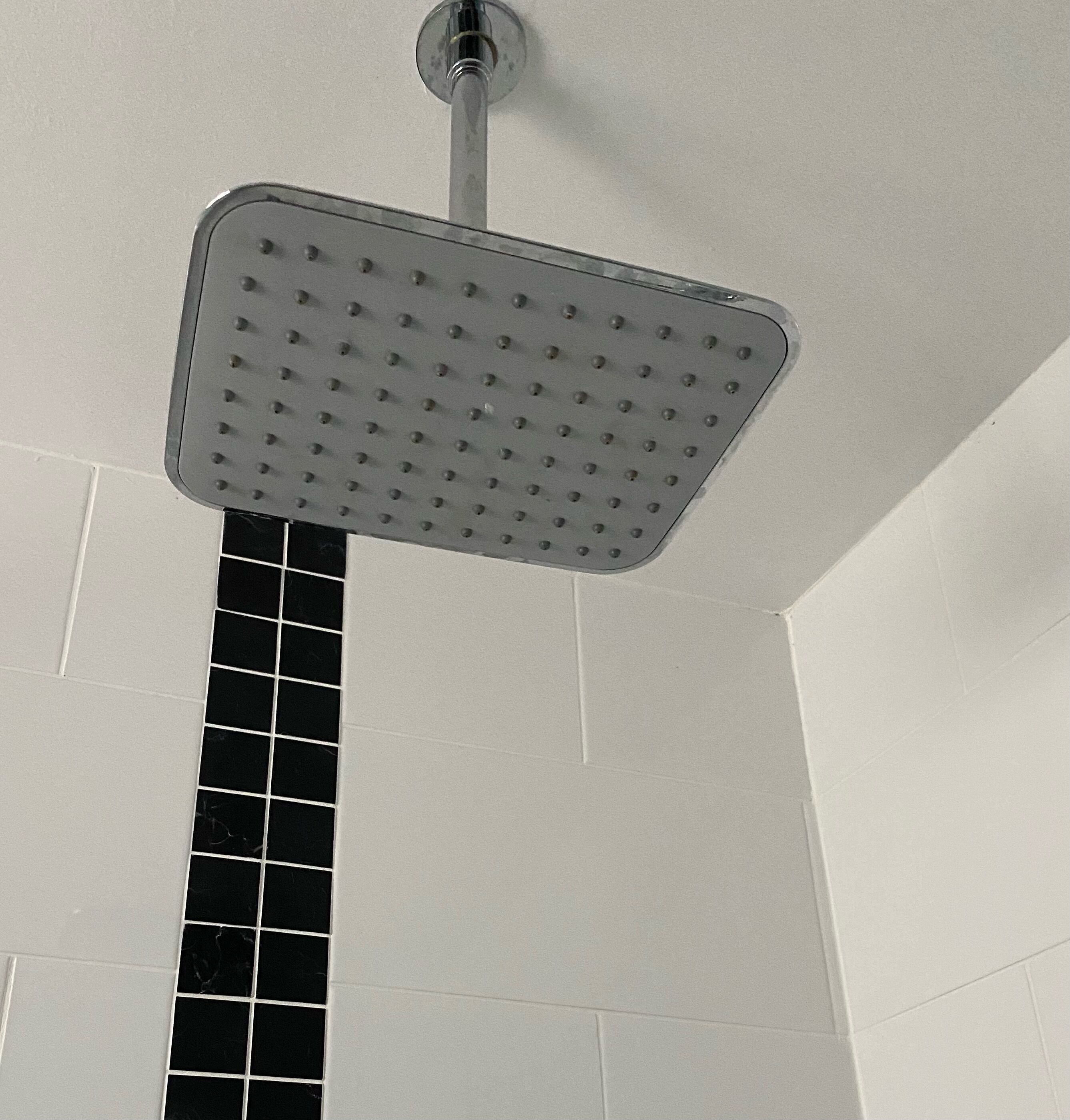 Un cabezal de ducha con diseño cuadrado y varios rociadores.