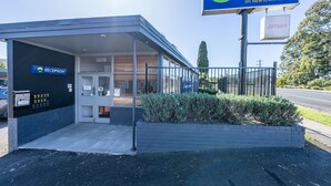 A motel with a reception area, a signboard, and a gated entrance. - Bega Motel (Bega)