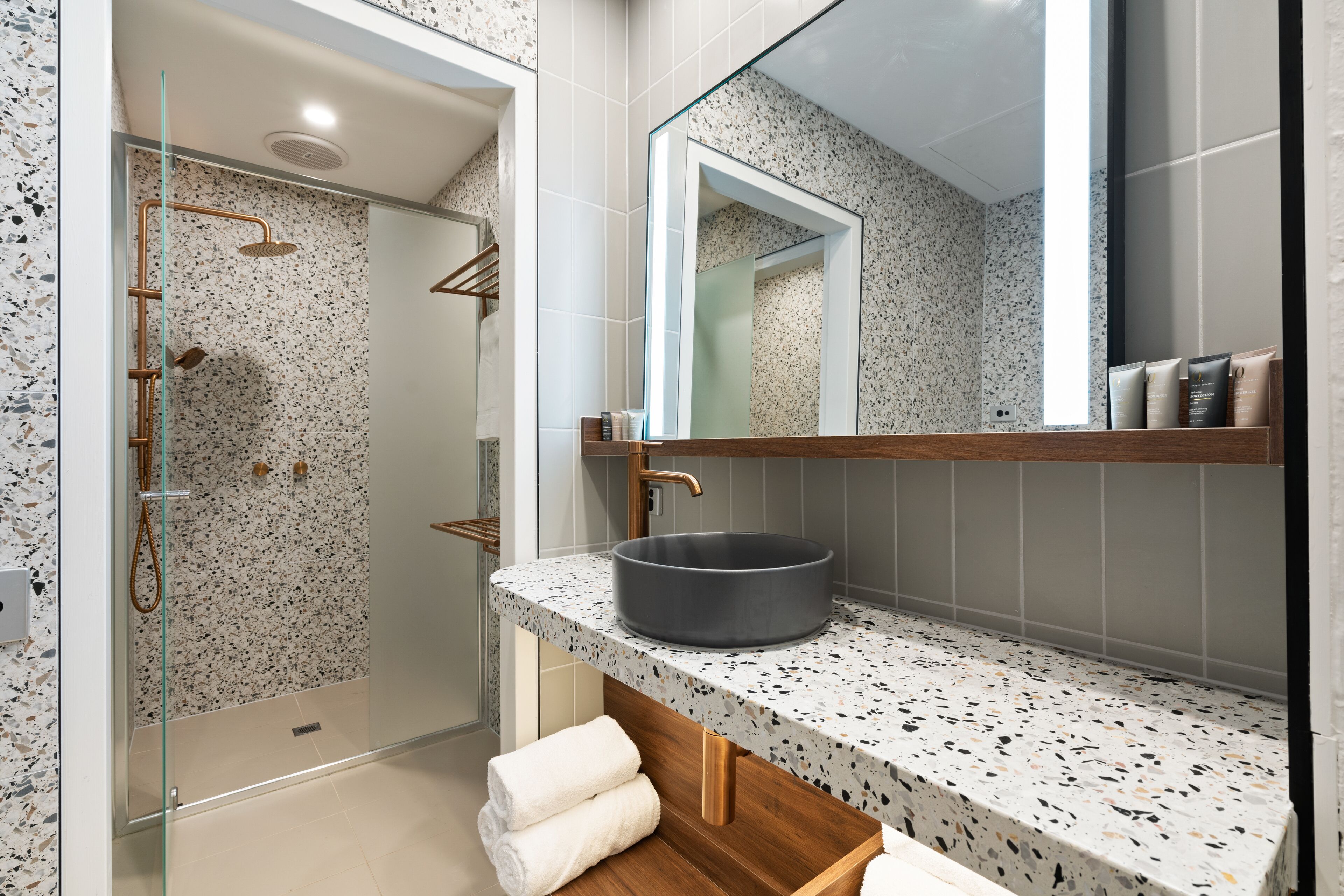 Une salle de bain moderne avec une baignoire sur pieds, un grand miroir et un comptoir en granit.