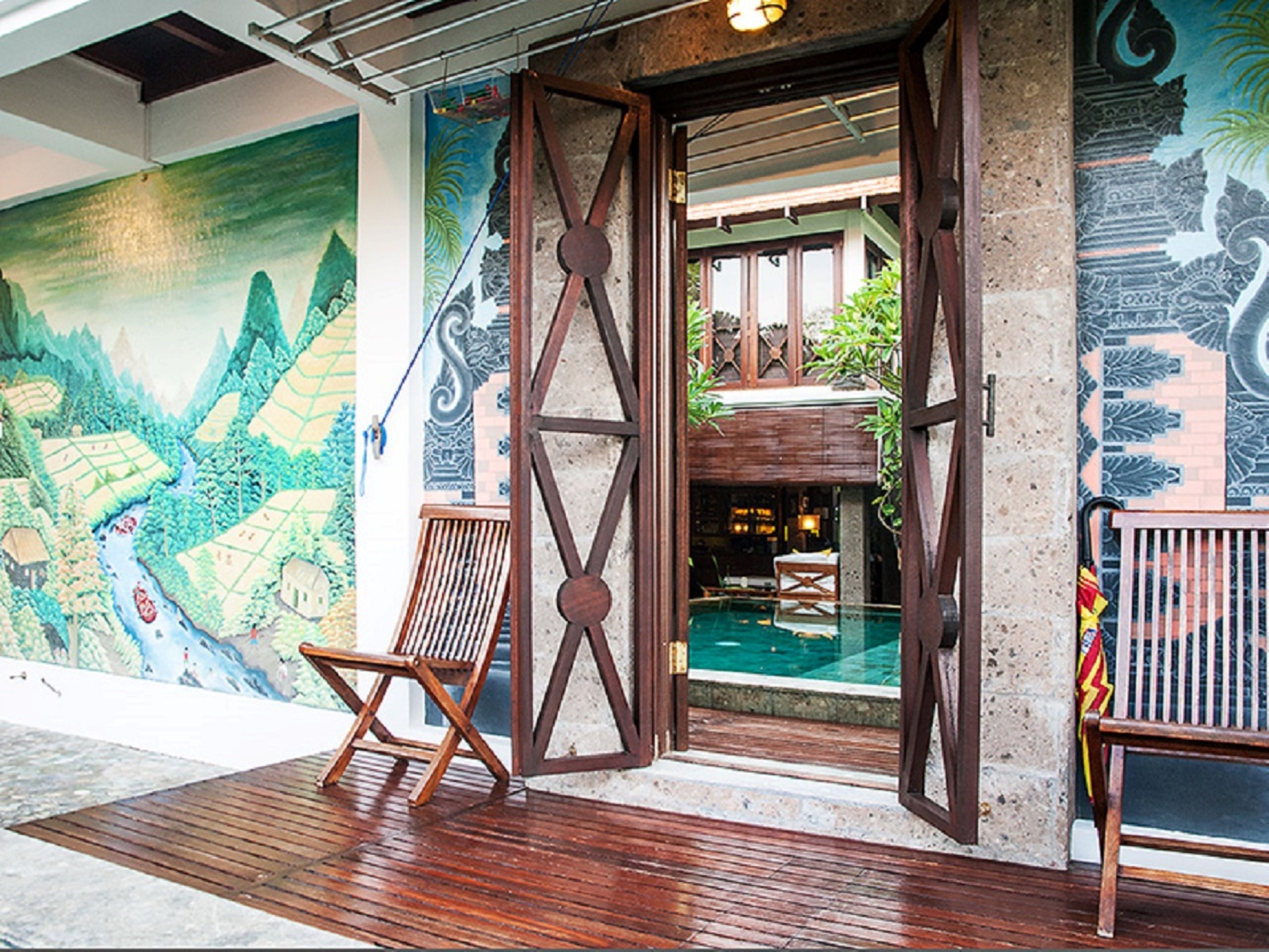 Um deck de madeira com um mural de paisagem montanhosa e área de piscina.
