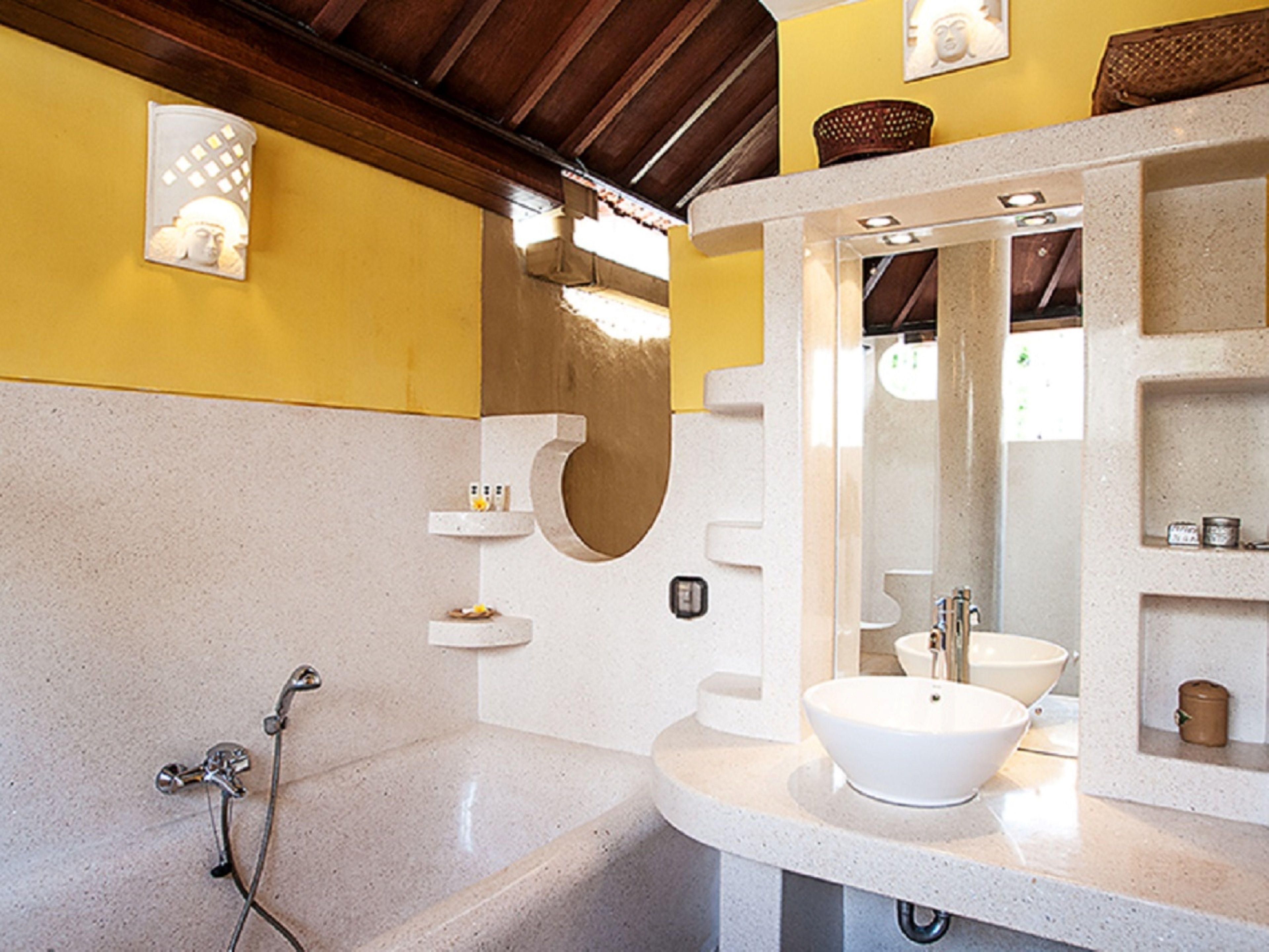 A bathroom with a freestanding bathtub, a large mirror, and a white sink.