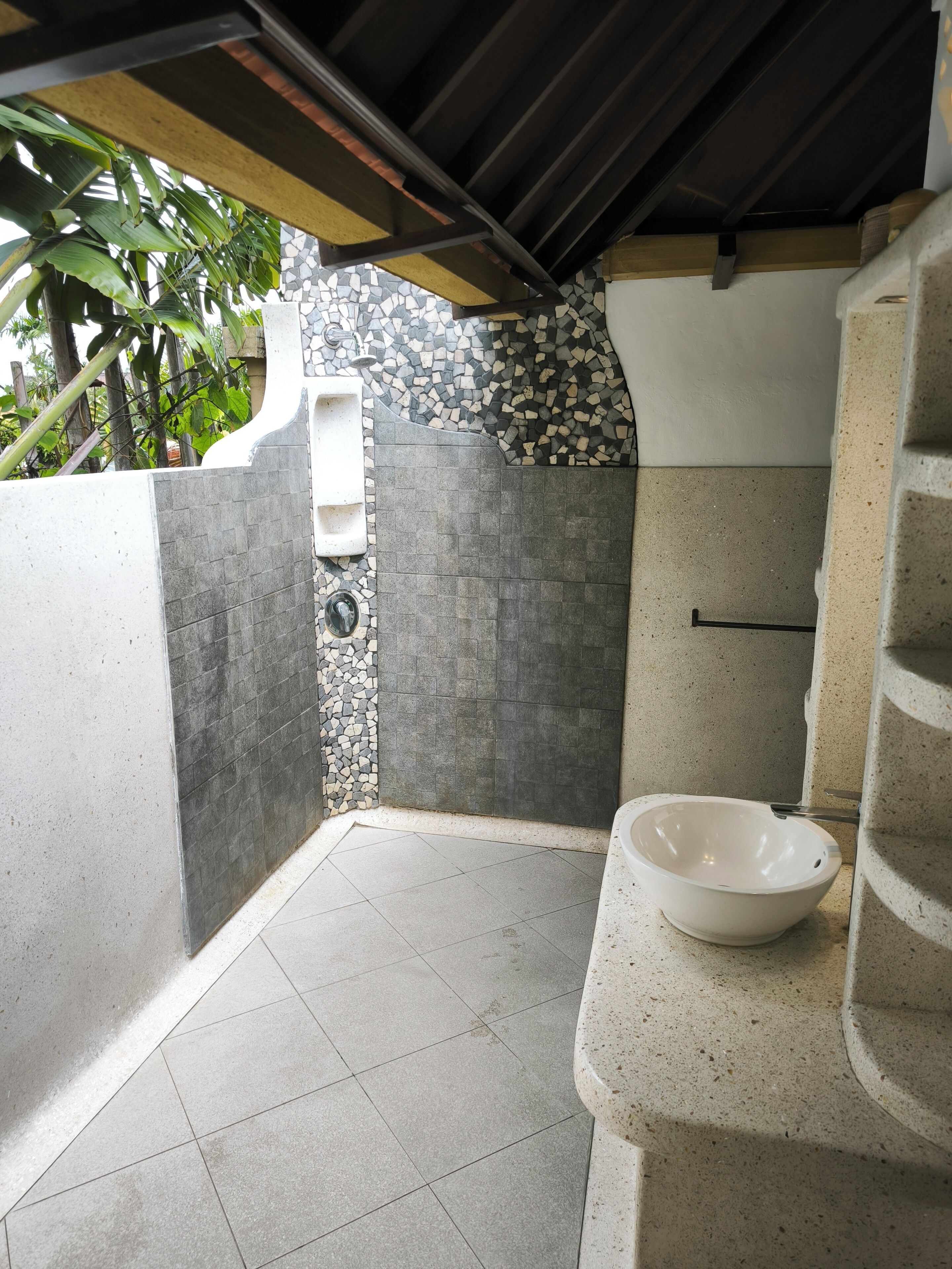 Uma casa de banho moderna com chuveiro, pia e sanita.