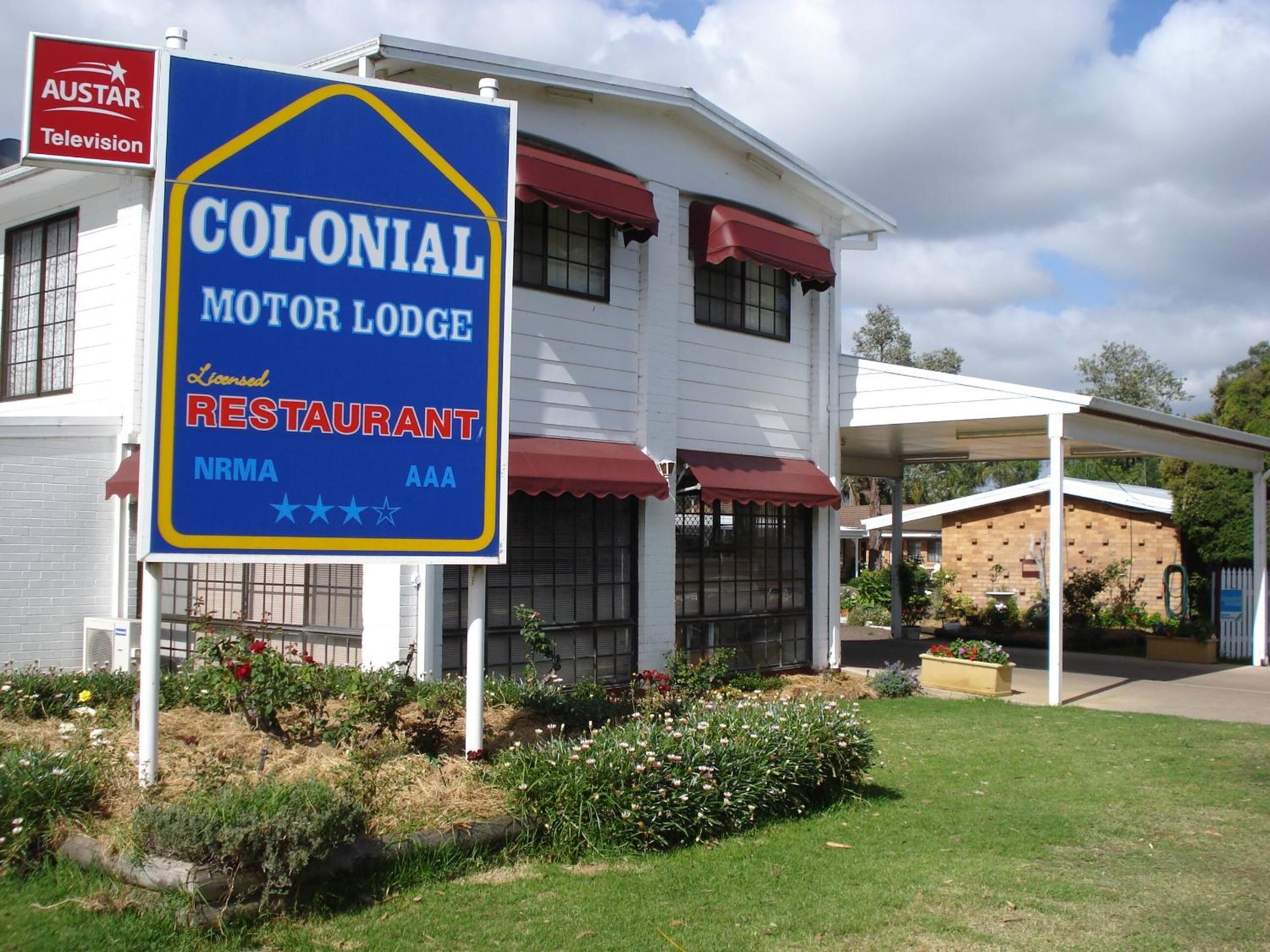 Una posada de estilo colonial con un cartel que indica que es un restaurante con licencia.
