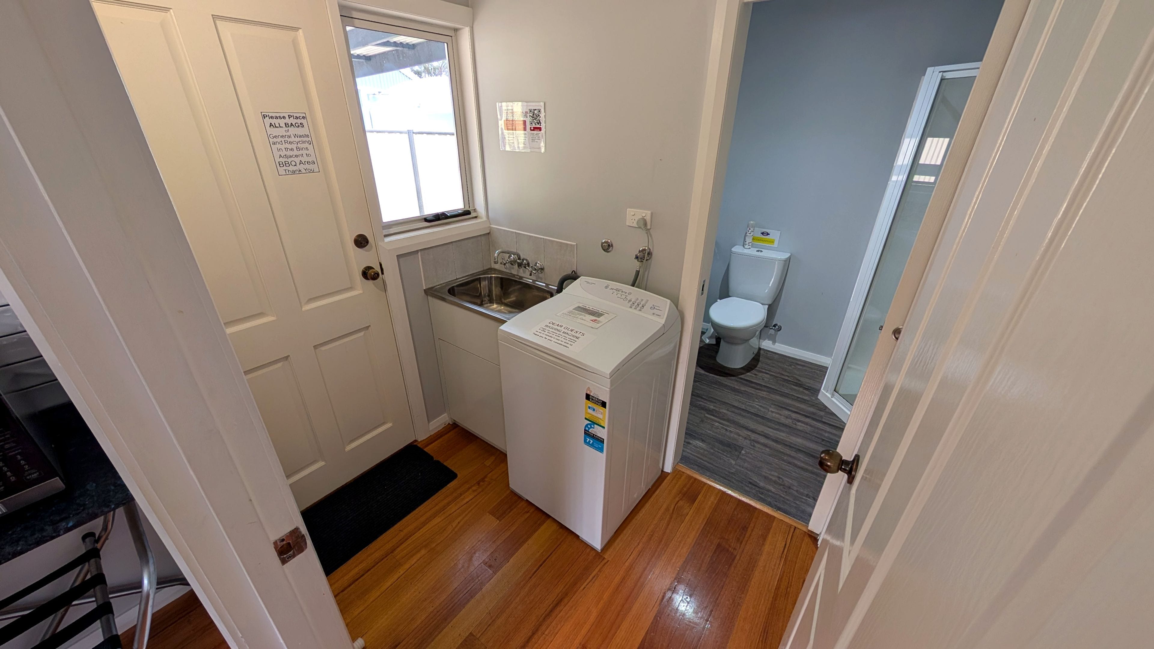 A compact bathroom with a sink, toilet, and a washing machine.