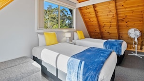 A bedroom with two beds, a window, a ceiling fan, and a view of trees. - Four Seasons Waterfront Villas (Taranna)